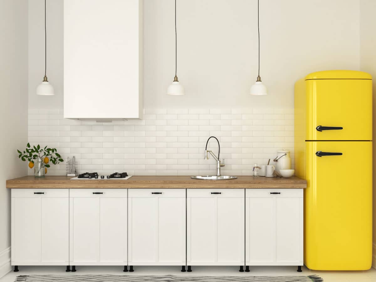 Kitchenette with white furniture and a yellow fridge
