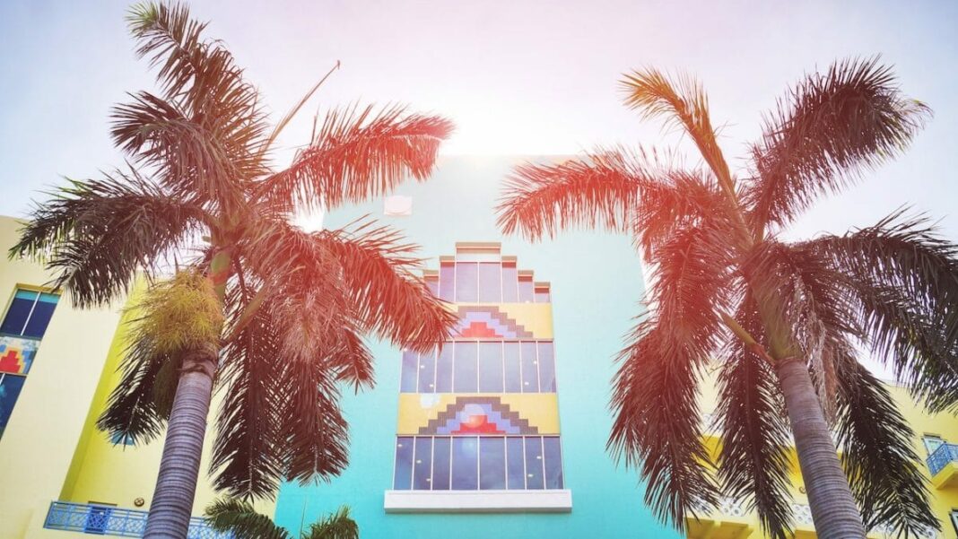 blue apartment with colorful pattern and palm trees in front