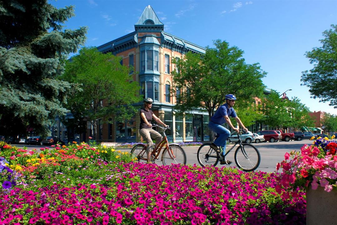 Two people riding a bike through Fort Collins