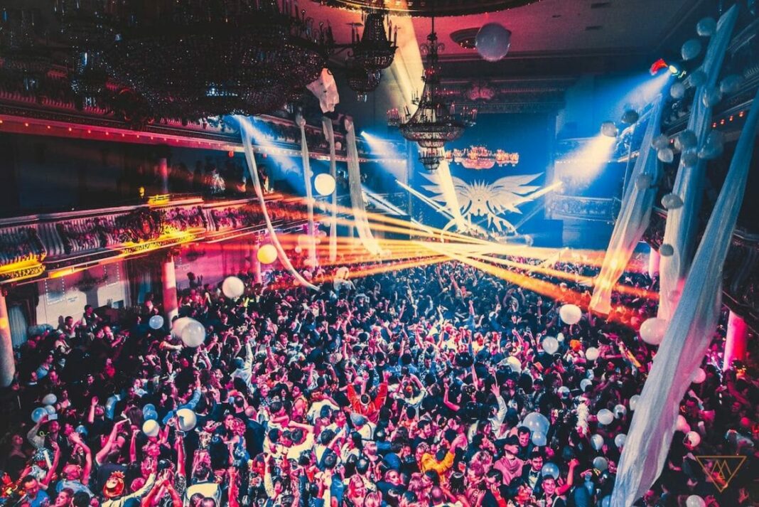 Ballroom with hundreds of people dancing at a party