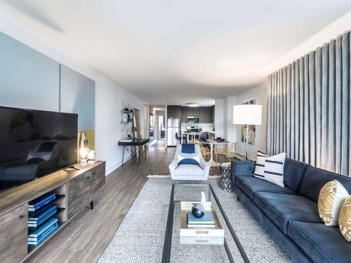 staged living room with tv,, couch table looking into the kitchen