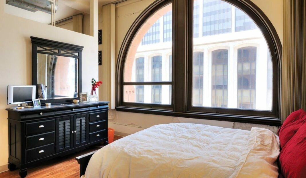bedroom with bed and, dresser, and half moon shaped window