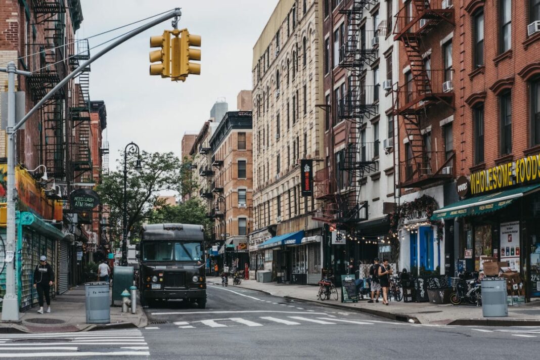People and cars on a street in Lower East Side, New York
