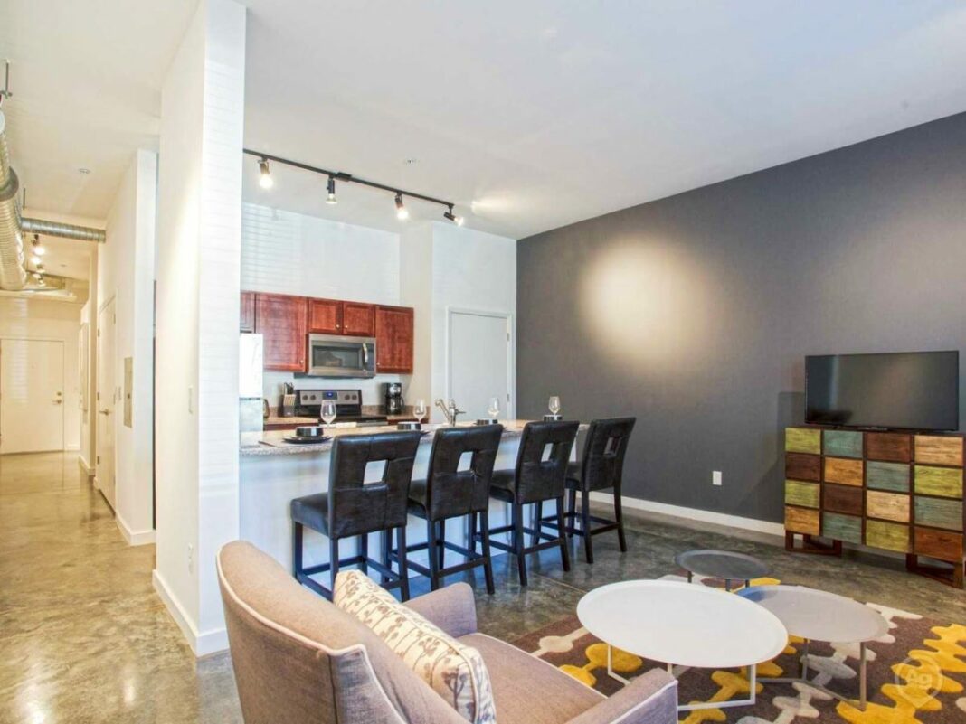 kitchen and living room staged with lights on