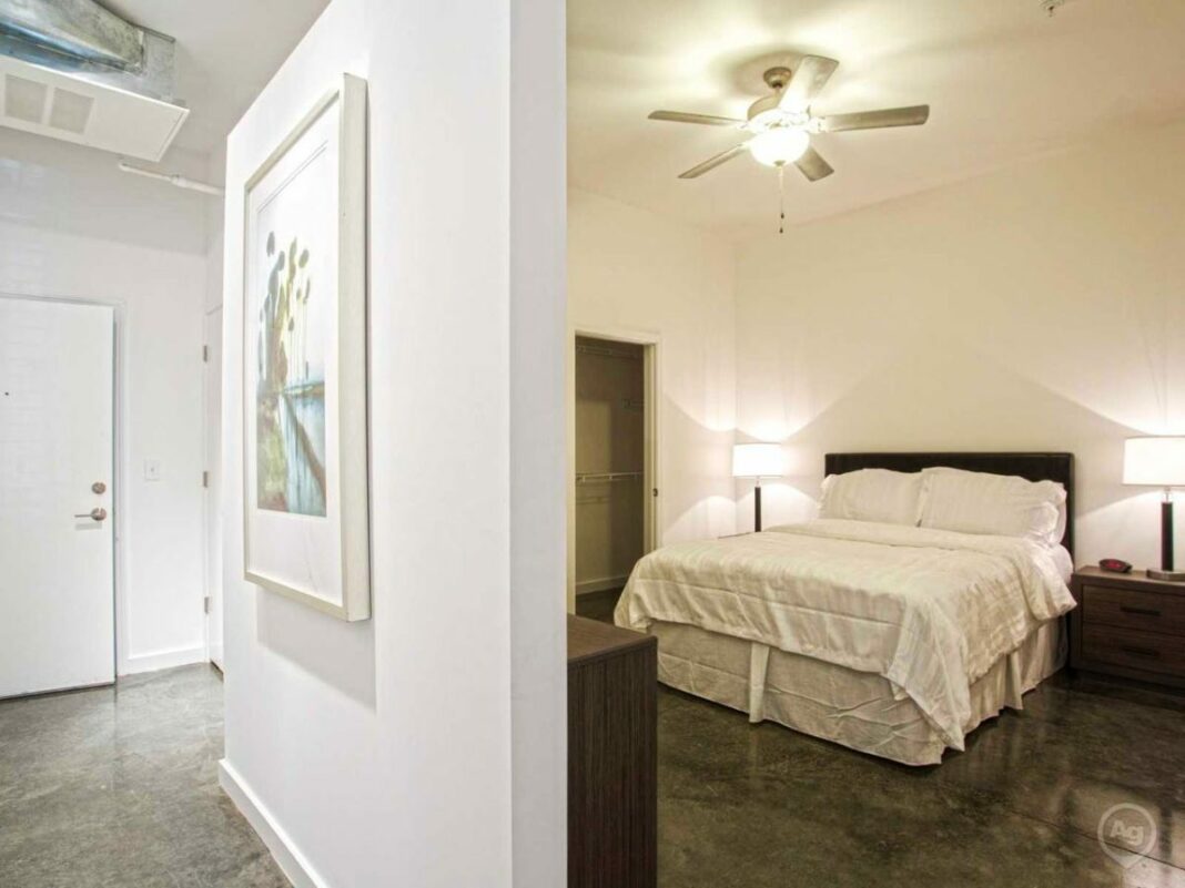 half wall showing a bedroom on the right side and hallway on the left side