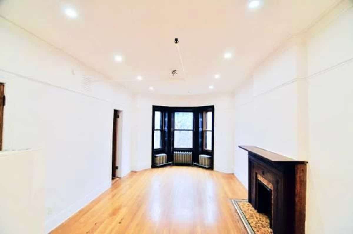 empty hardwood floored living room facing the front window