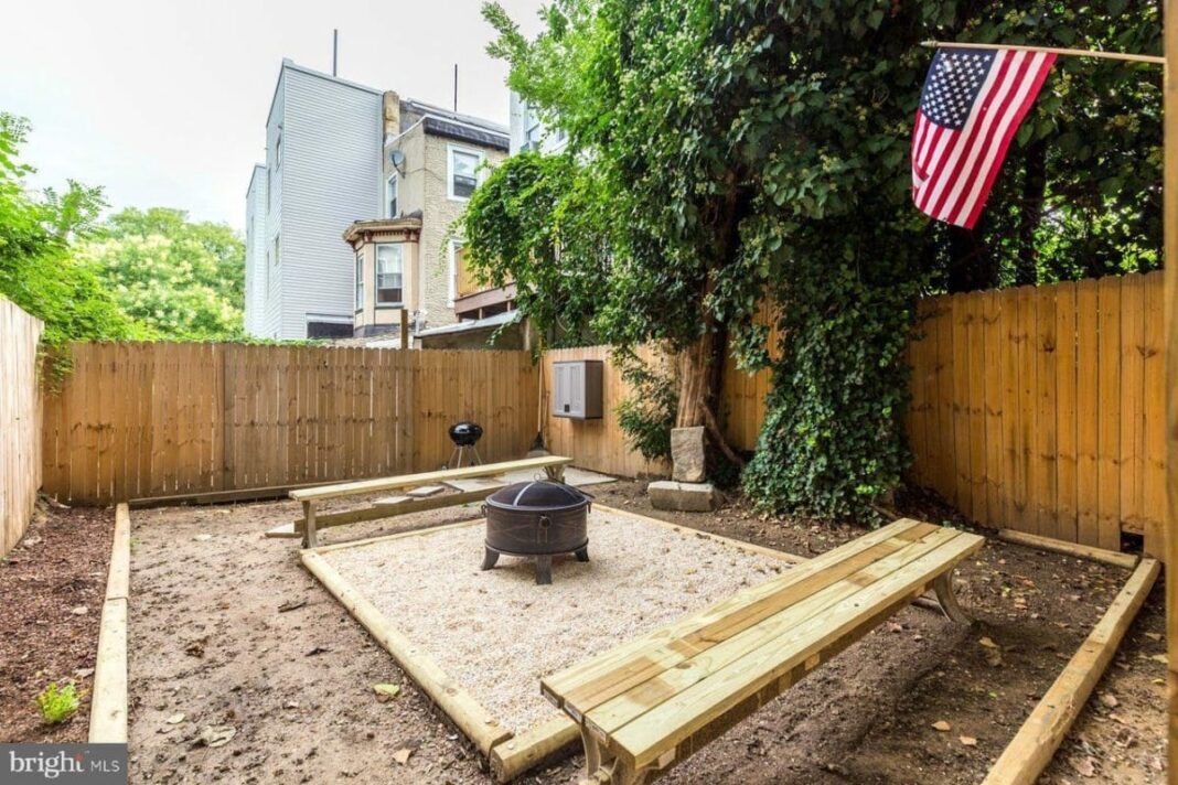 baackyard with fire pit and wooden benches