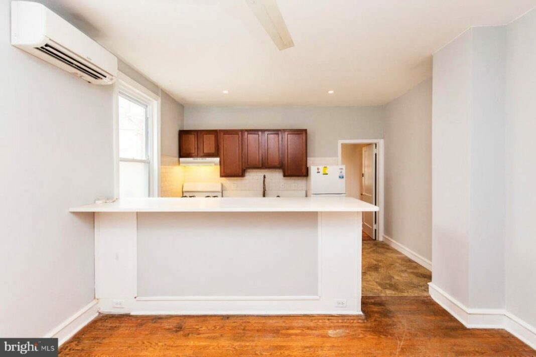 looking into kitchen from living room, hardwood floors and lots of natural light