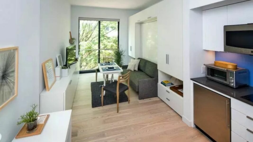 living room of micro unit with window facing green trees outside