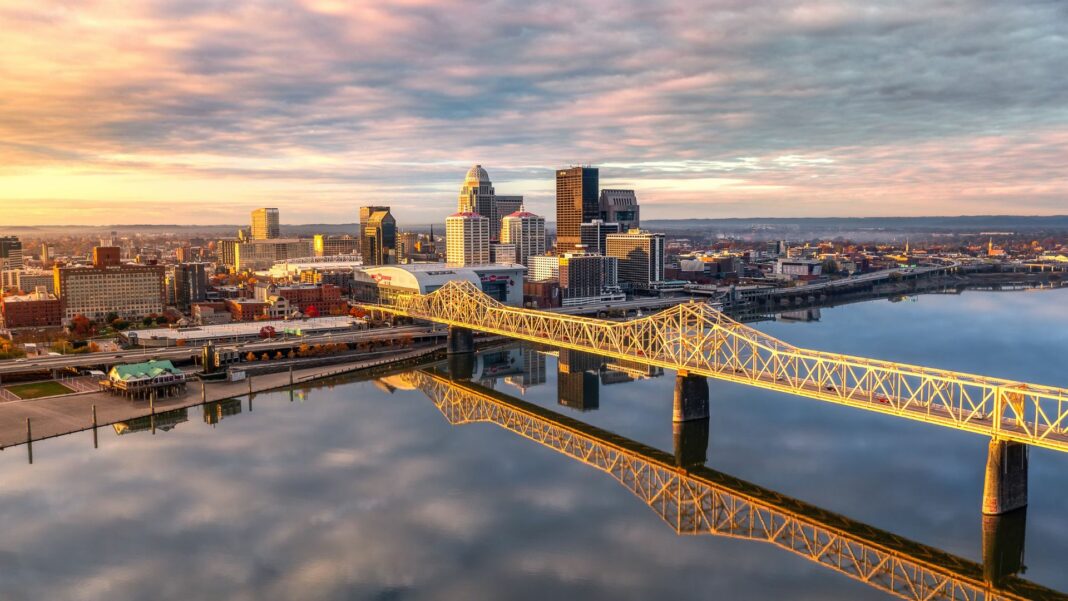 An aerial shot of the skyline of Louisville and the bridge at sunrise.